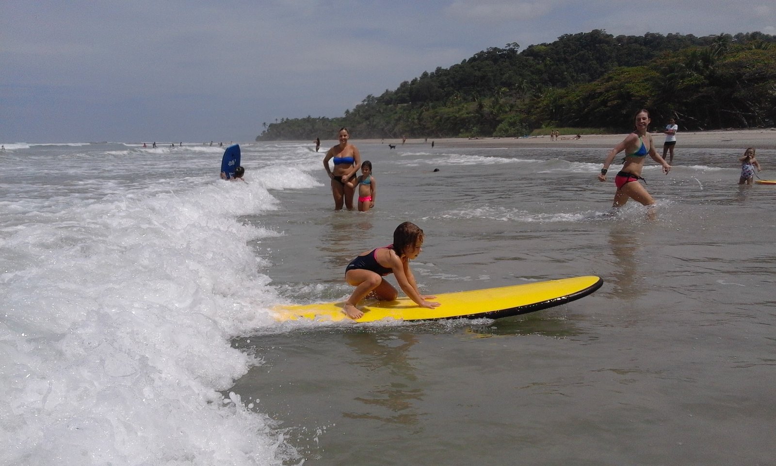 Family enjoying a beginner surf session on the Pacific coast